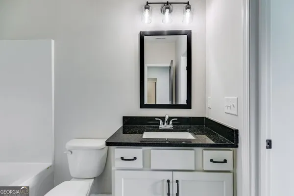 a bathroom with a toilet sink and mirror