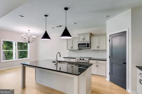 a kitchen with stainless steel appliances granite countertop a sink a stove and a refrigerator