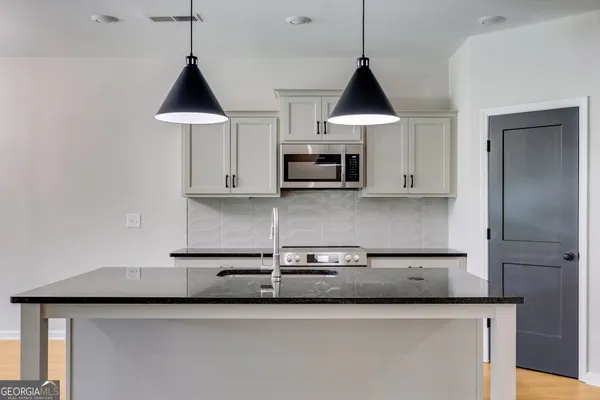 a kitchen with stainless steel appliances granite countertop a sink a stove and a microwave