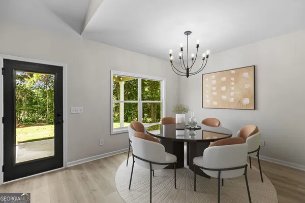 a dining room with furniture a chandelier and wooden floor