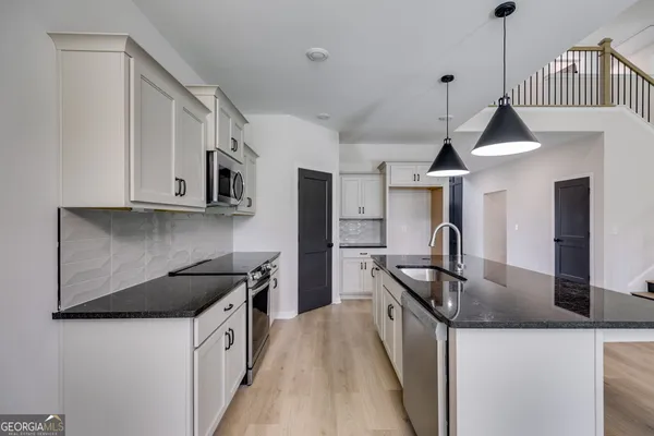 a kitchen with stainless steel appliances granite countertop a sink a stove and a refrigerator