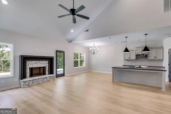 an empty room with wooden floor a fireplace and windows