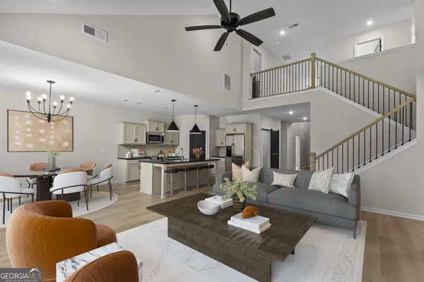 a living room with furniture kitchen view and a chandelier