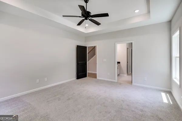 an empty room with closet and a ceiling fan
