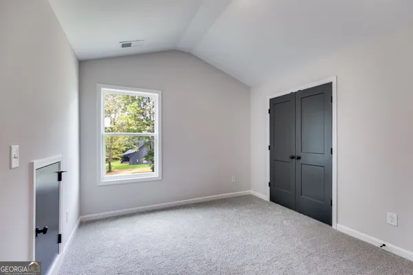 an empty room with windows and closet