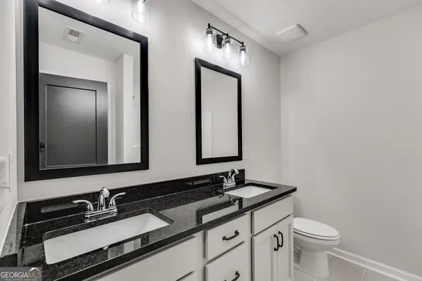 a bathroom with a double vanity sink and a mirror