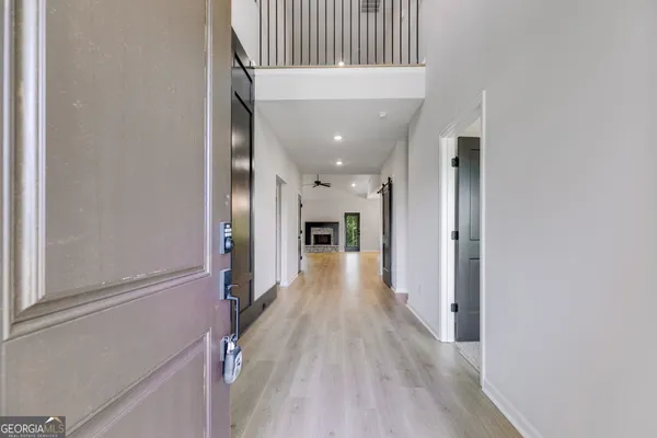 a view of a hallway with wooden floor and staircase