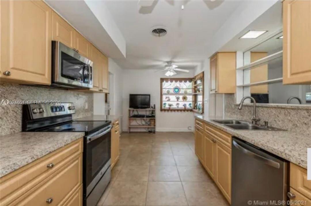 3619 West Park Road Hollywood, FL 33021 - Photo 6 of 19 a kitchen with stainless steel appliances granite countertop a sink stove and microwave