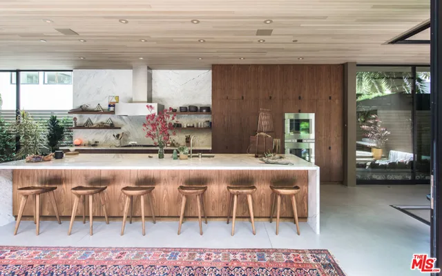 a dining hall with a stove a table and chairs