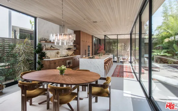 a dining room with furniture and a floor to ceiling window