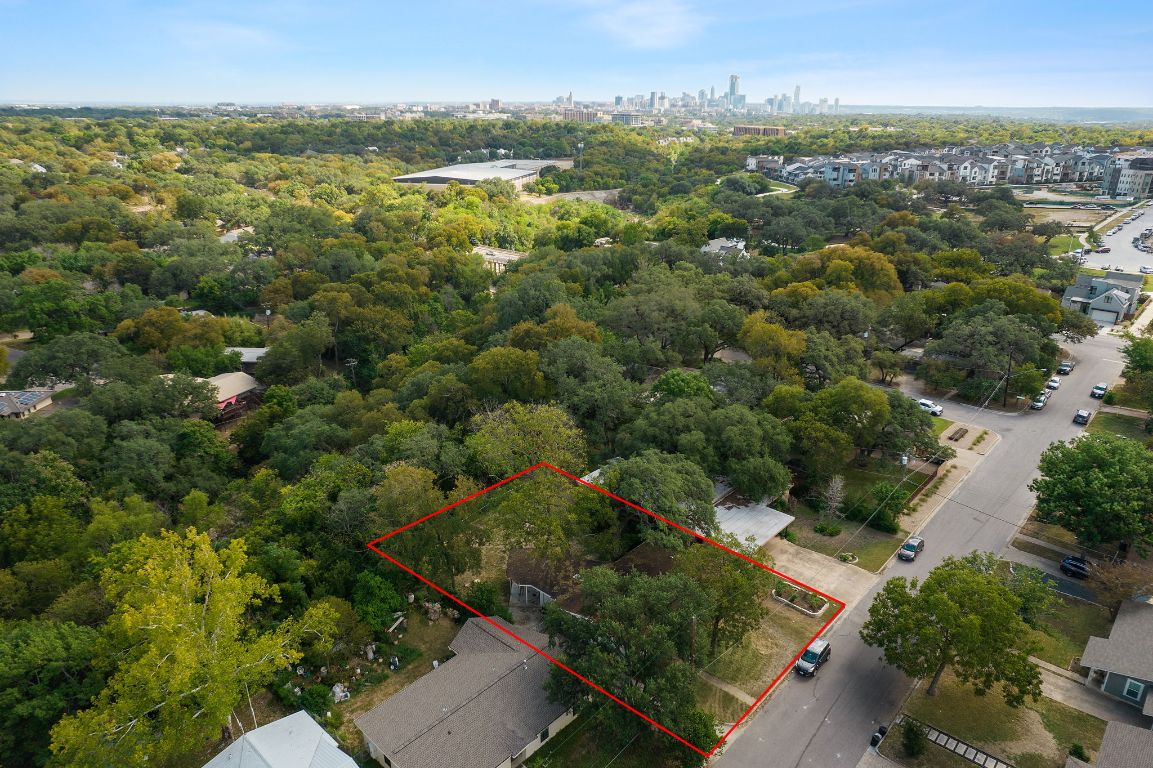 an aerial view of residential houses with outdoor space and trees