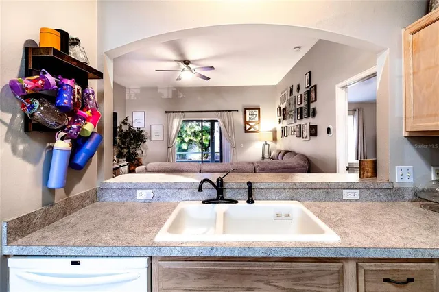a living room with stainless steel appliances furniture a chandelier and a view of kitchen