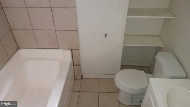 a white toilet sitting next to a white tub
