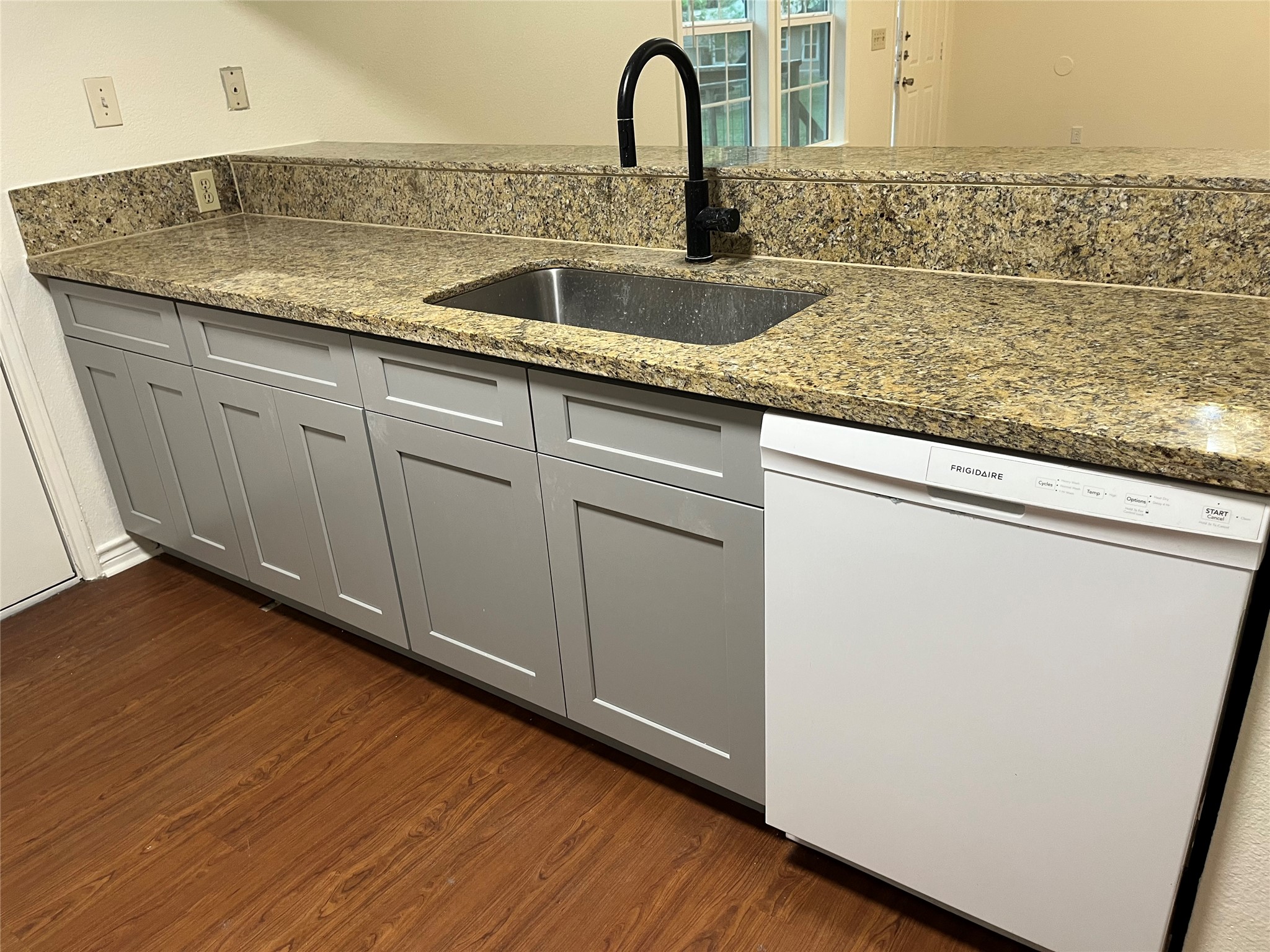 23393 Nameless Road, Unit 144 Leander, TX 78641 - Photo 8 of 23 Kitchen featuring gray cabinets, dark wood finished floors, dark stone counters, a sink, and dishwasher