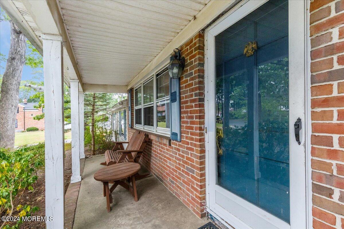 106 Forest Road Brick, NJ 08724 - Photo 2 of 23 a porch with a bench next to a window