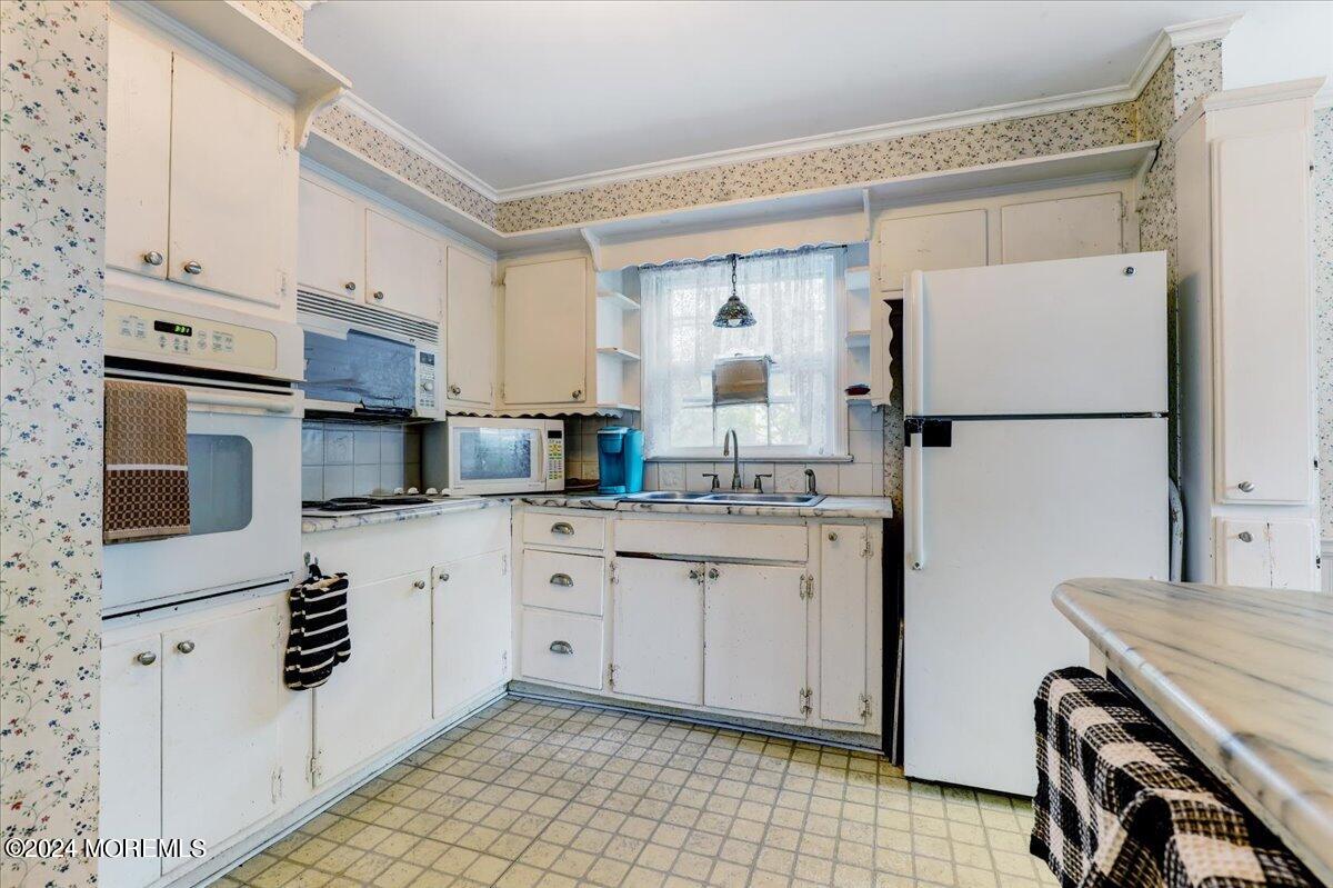 106 Forest Road Brick, NJ 08724 - Photo 7 of 23 a kitchen with white cabinets and white appliances