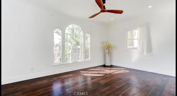 an empty room with windows and wooden floor