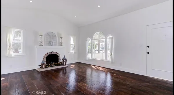 a living room with wooden floor and a fireplace