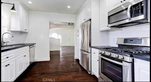 a kitchen with stainless steel appliances a stove microwave and cabinets