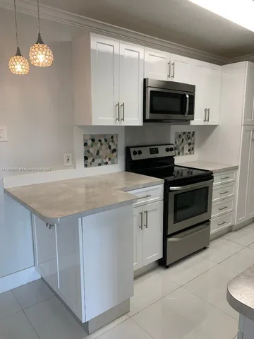 a kitchen with stainless steel appliances a stove a microwave sink and cabinets