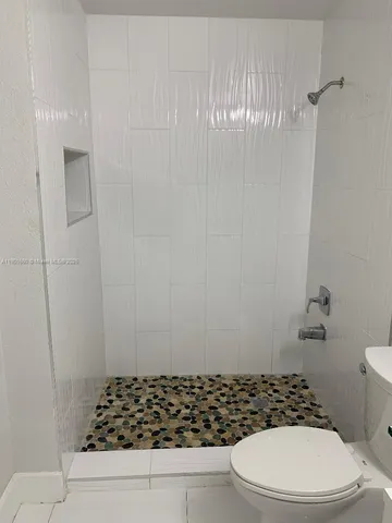 a bathroom with a toilet and a shower