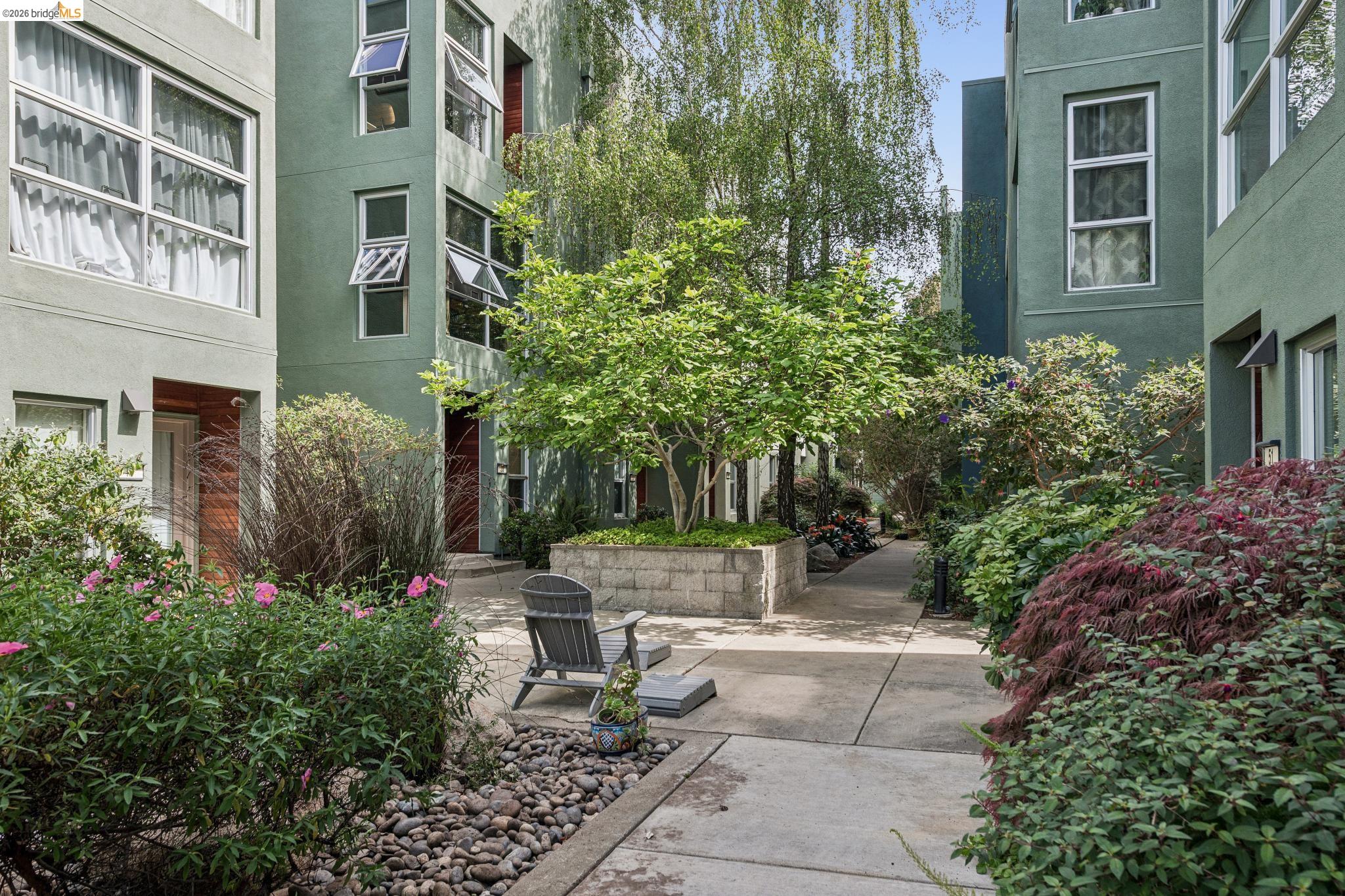61 Glashaus Loop Emeryville, CA 94608 - Photo 37 of 39 a view of a backyard with plants and brick walls