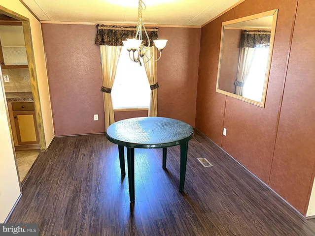 a view of a room with wooden floor and a chandelier