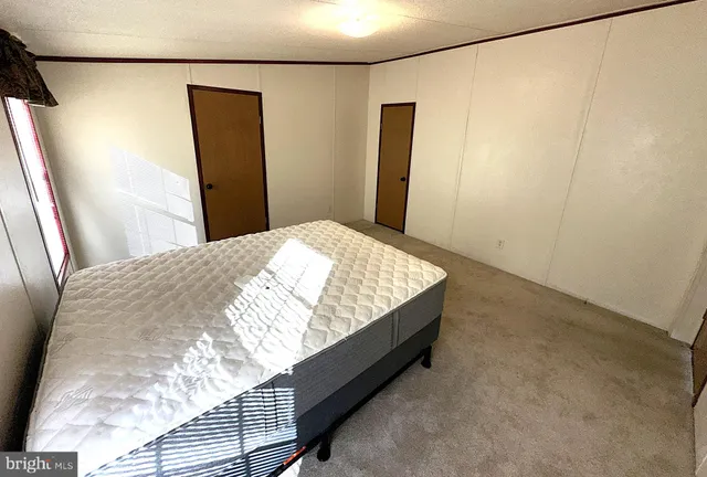 a bed sitting in a bedroom next to a bathroom