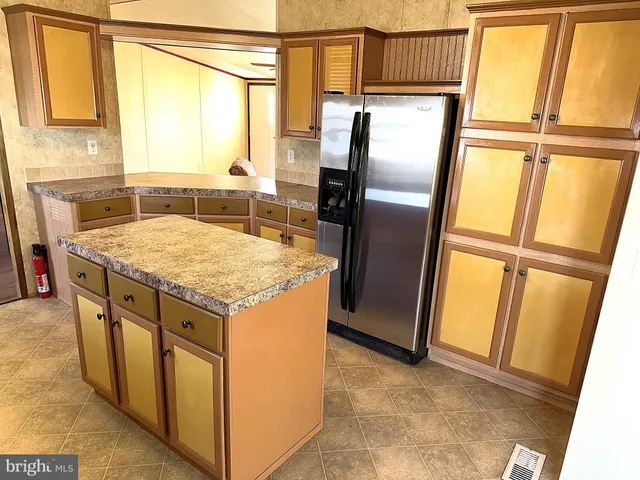 a kitchen with stainless steel appliances granite countertop a refrigerator and a counter