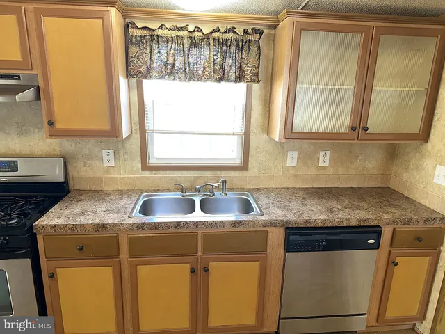 a kitchen with granite countertop a sink a counter space and a window