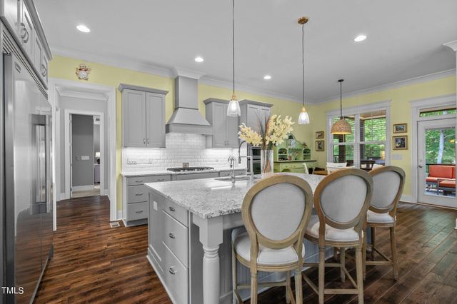 a kitchen with granite countertop a stove a sink and a refrigerator