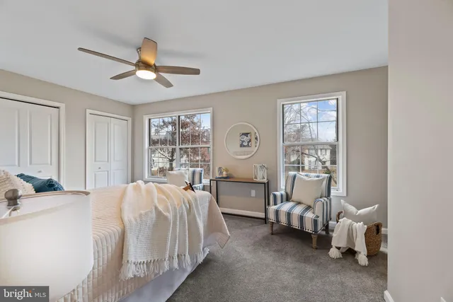 a bedroom with bed and two large window