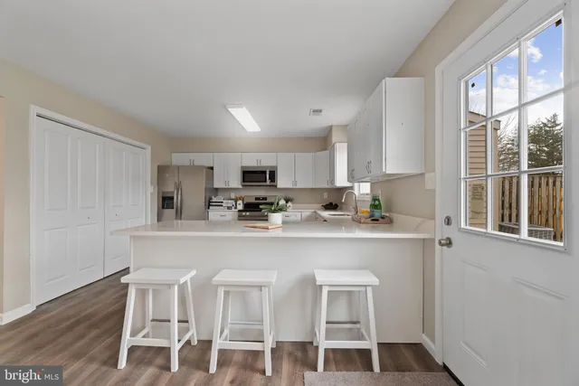 a kitchen with white cabinets and sink