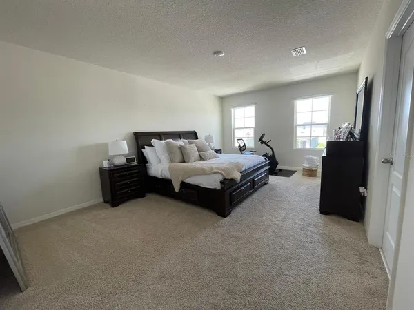 a spacious bedroom with a bed and window