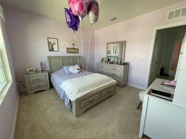 a bedroom with a bed dresser and window