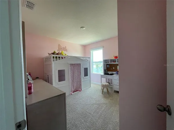 a bedroom with a bed and a view of kitchen