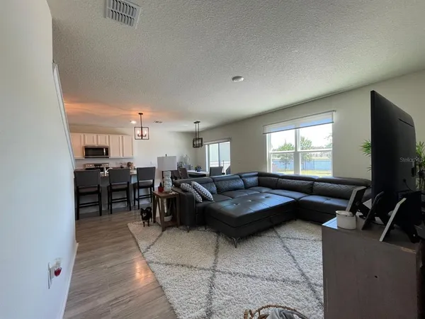 a living room with lots of furniture and kitchen view