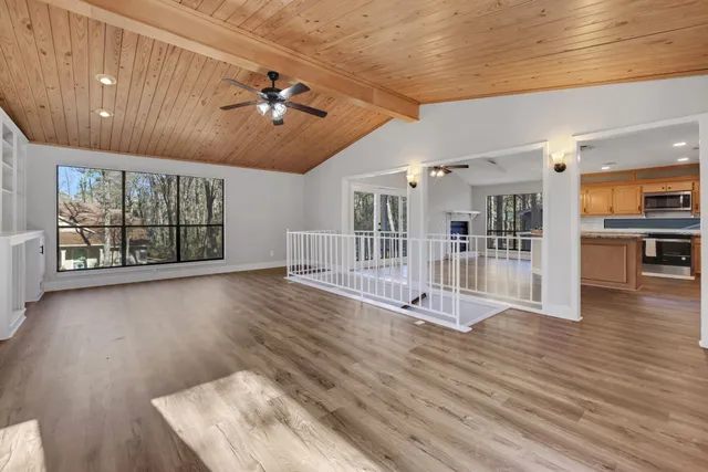 a view of an empty room with a window and fireplace