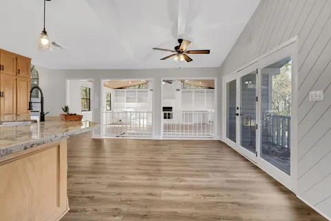 a view of a bathroom with wooden floor and mirror