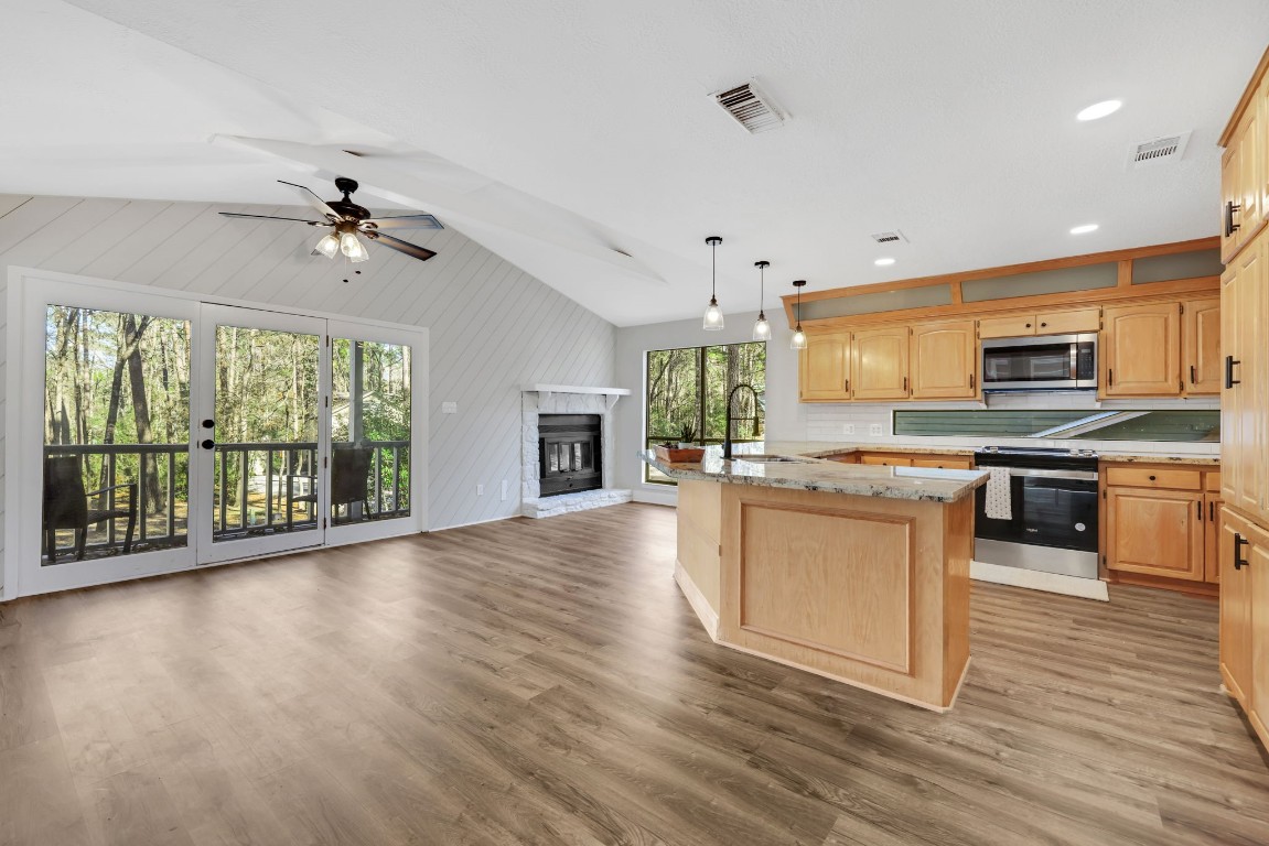 330 North Fairway Loop Coldspring, TX 77331 - Photo 6 of 40 a kitchen with stainless steel appliances granite countertop a stove top oven a sink dishwasher a refrigerator and cabinets with wooden floor