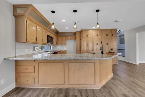 a kitchen with stainless steel appliances granite countertop a sink a stove and a microwave oven