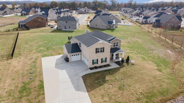 an aerial view of a house with swimming pool and mountains