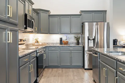 a kitchen with a refrigerator sink and cabinets