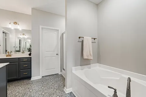 a bathroom with a tub sink and mirror