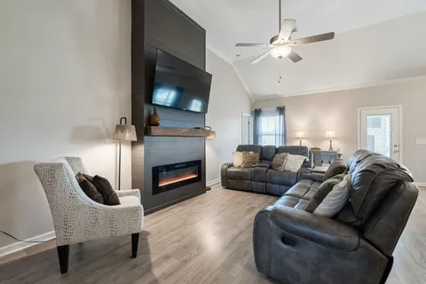 a living room with furniture a flat screen tv and a fireplace