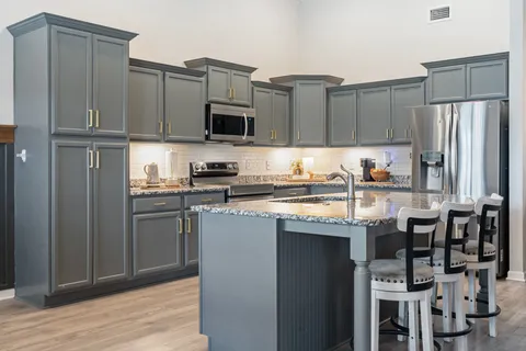 a kitchen with stainless steel appliances granite countertop a refrigerator sink and cabinets