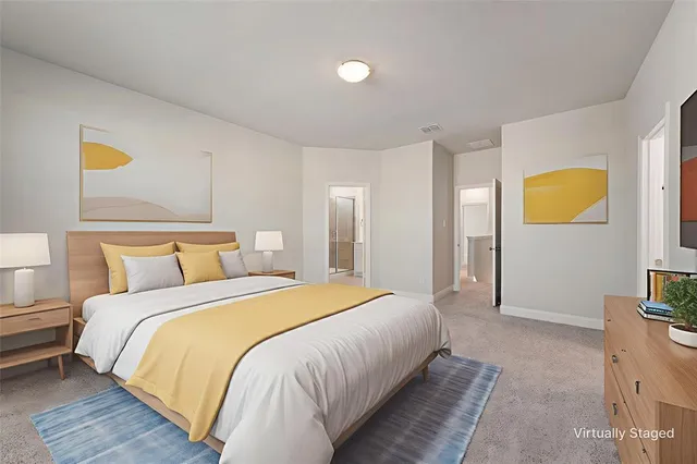 a spacious bedroom with a bed and painting on the wall