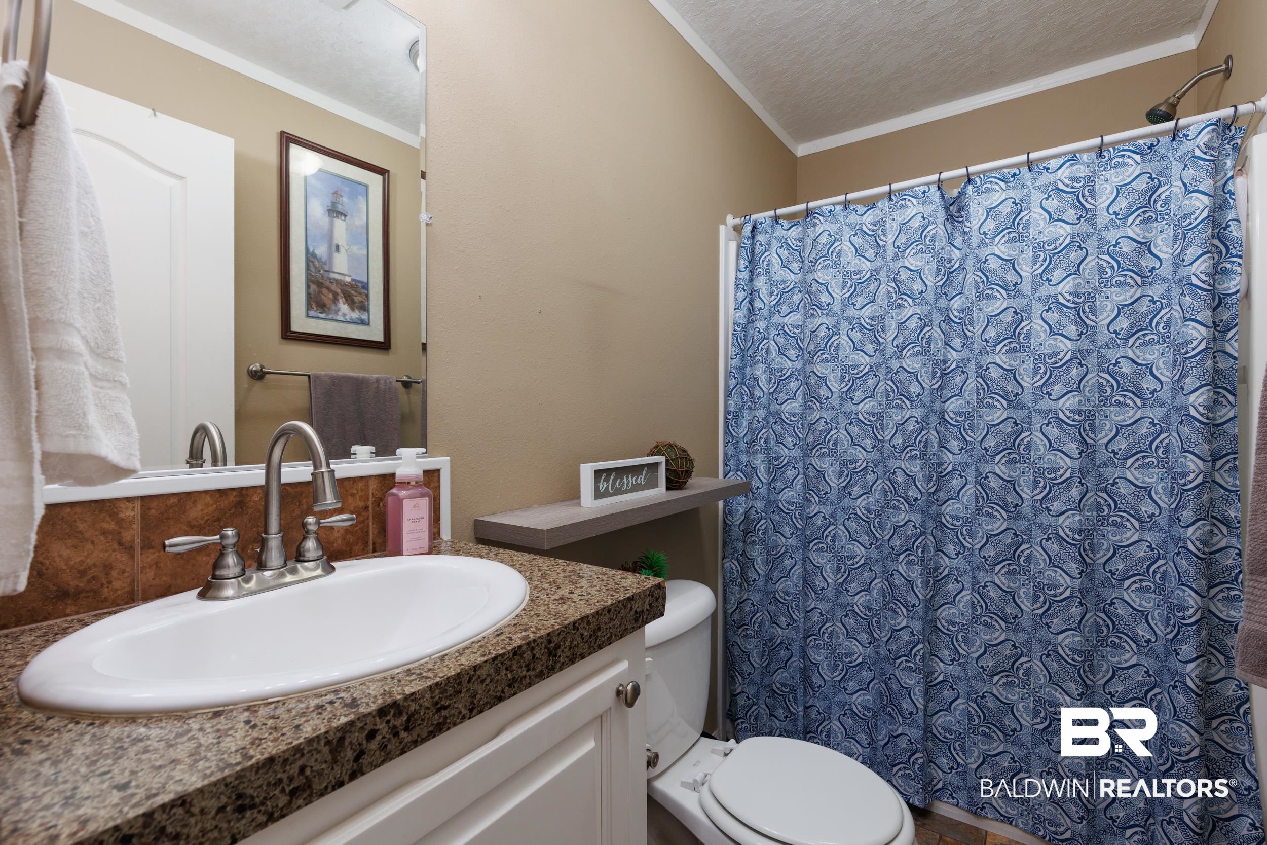 6725 Upper Creek Road Flomaton, AL 36441 - Photo 46 of 61 Full bathroom featuring crown molding, toilet, vanity, a shower with curtain, and a textured ceiling