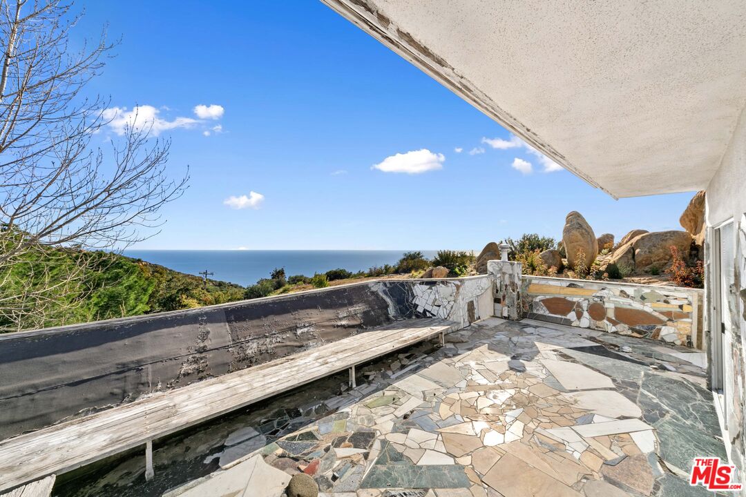 24641 Piuma Road Malibu, CA 90265 - Photo 30 of 40 a view of a balcony with two chairs and a table