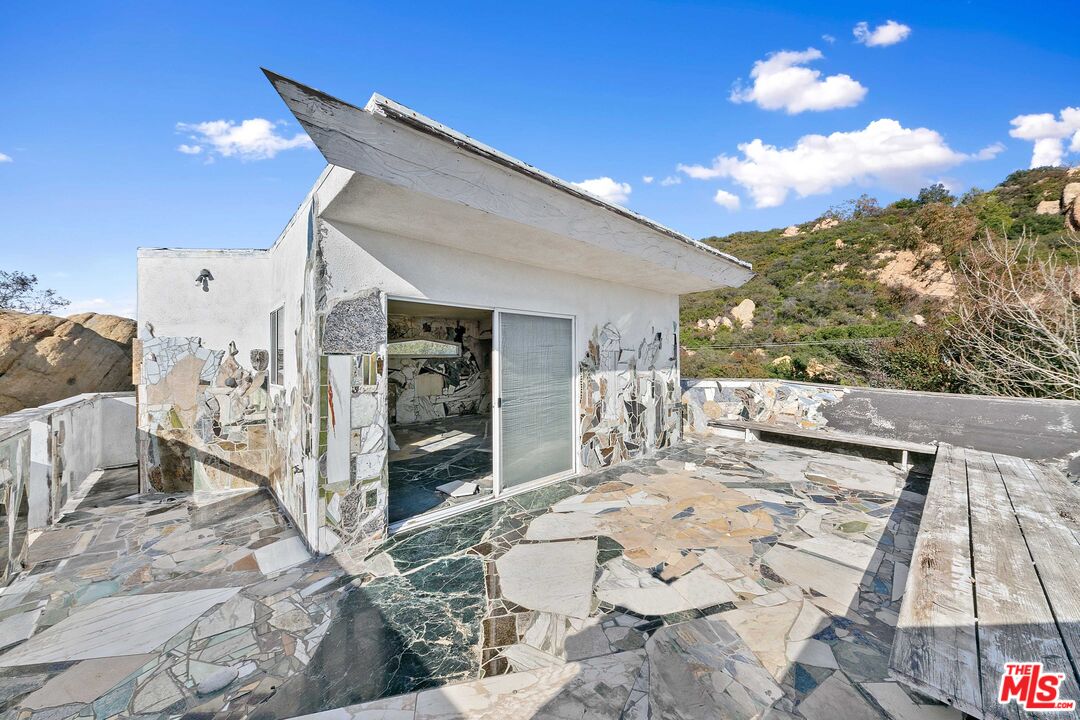 24641 Piuma Road Malibu, CA 90265 - Photo 32 of 40 a view of a patio with dining table and chairs with wooden floor